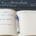 A trading journal reading I'm learning to trade beside a laptop chart on a wooden desk